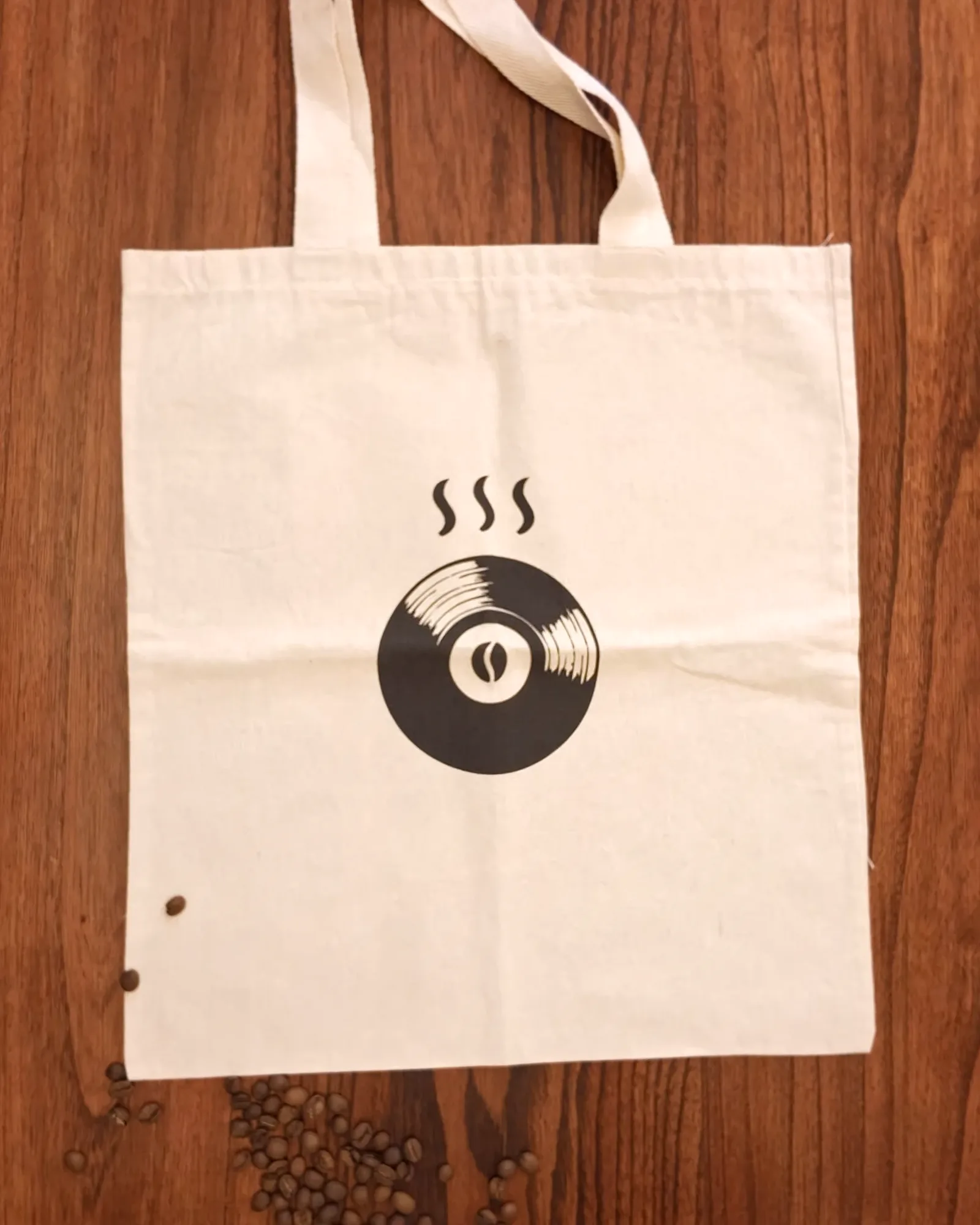 Totebag beige con un vinilo negro adentro.